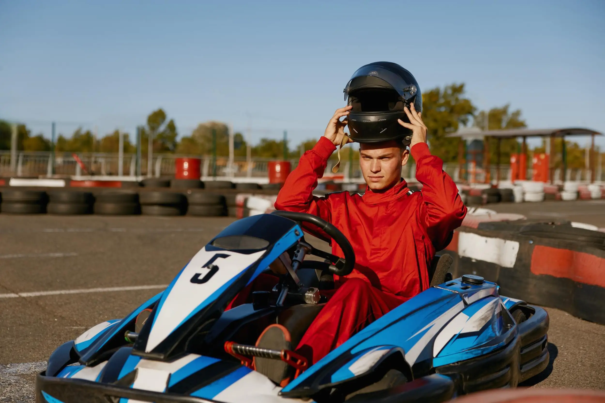 monsieur qui enlève son casque sur un karting à l'arret